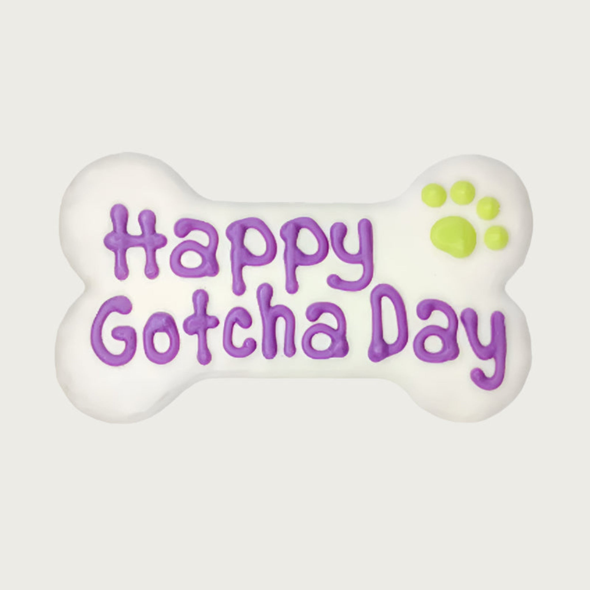 White, bone-shaped dog cookie with 'Happy Gotcha Day' text in purple and a lime green paw print.