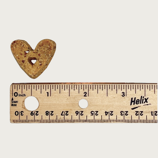 One heart-shaped treat next to a ruler to show size. It is about 1.25" long.
