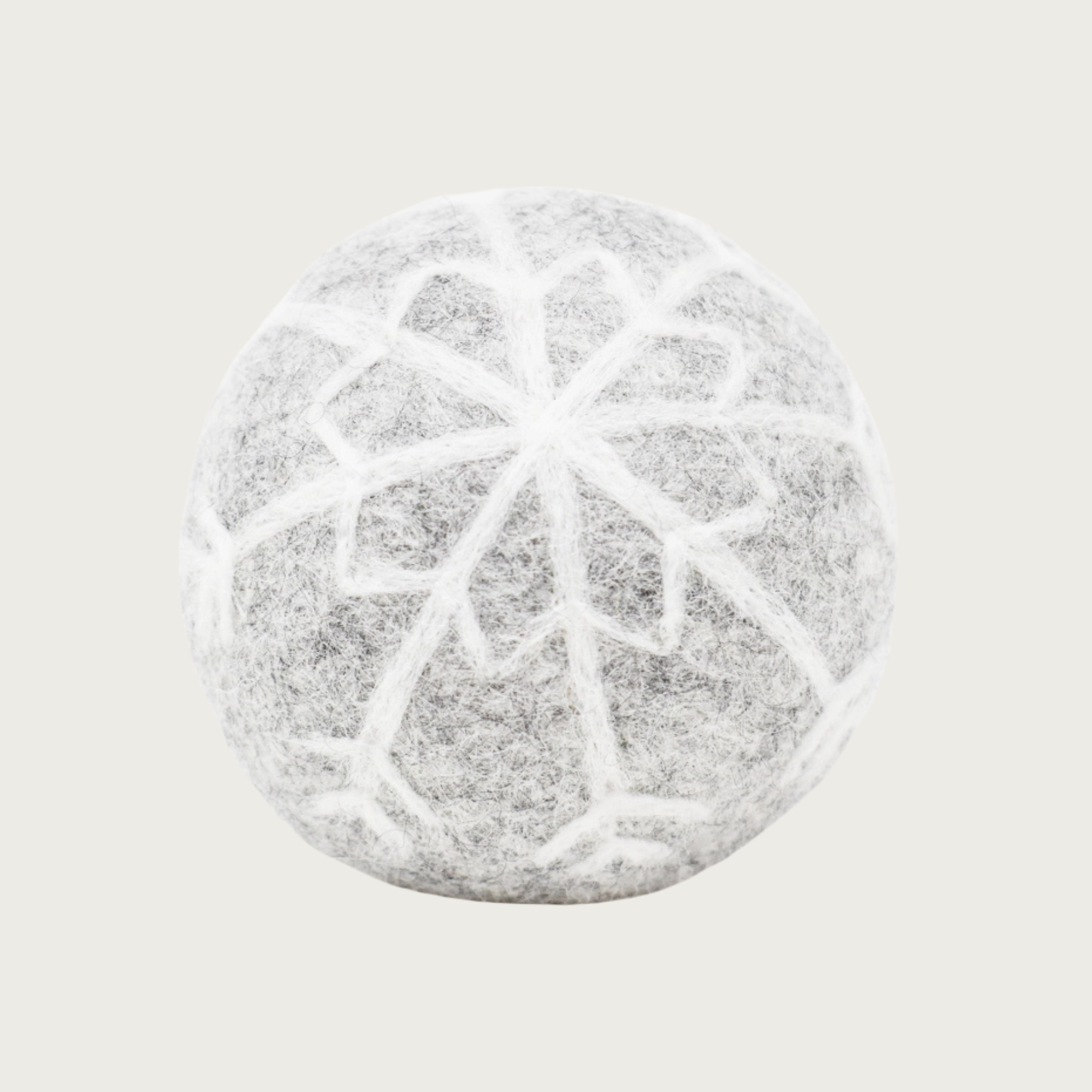 Pale gray felted wool ball with a white snowflake design covering the entire ball.