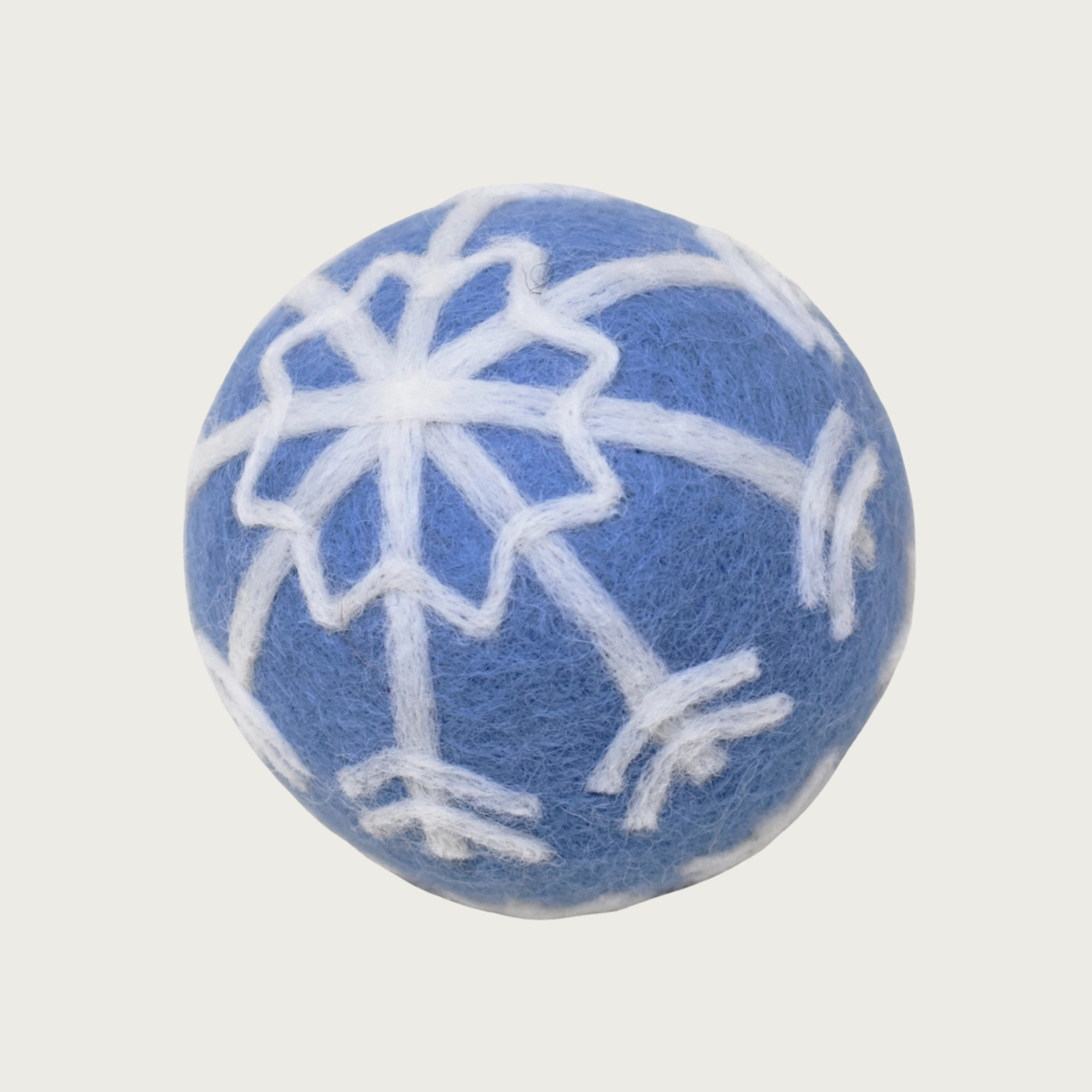 Medium-blue hued felted wool ball with a white snowflake design covering the entire ball.