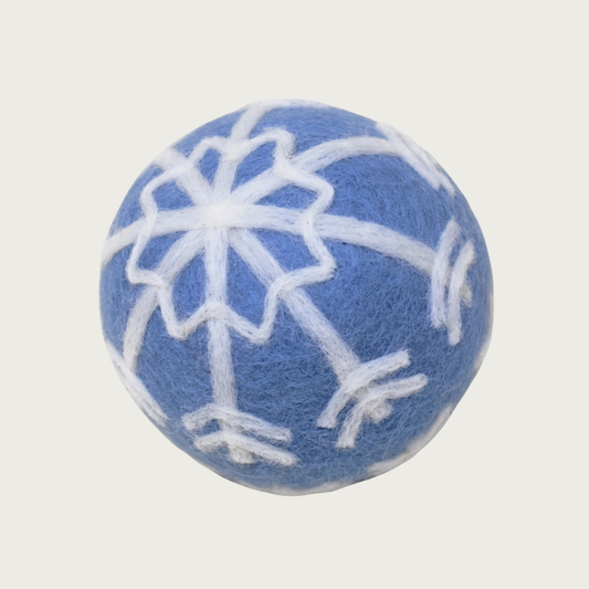 Medium-blue hued felted wool ball with a white snowflake design covering the entire ball.