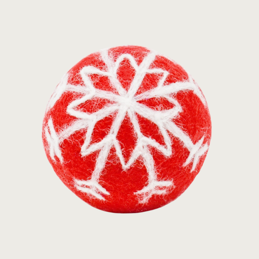 Red felted wool ball with a white snowflake design covering the entire ball.