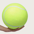 Load image into Gallery viewer, Large, bright yellow-green tennis ball dog toy held in a hand to show size & scale. It is approximately the size of a basketball.
