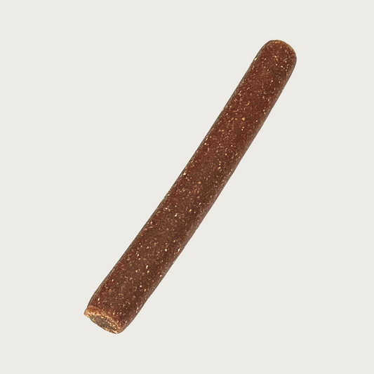 Brown, cylindrical stick shaped lamb crunchy dog chew.