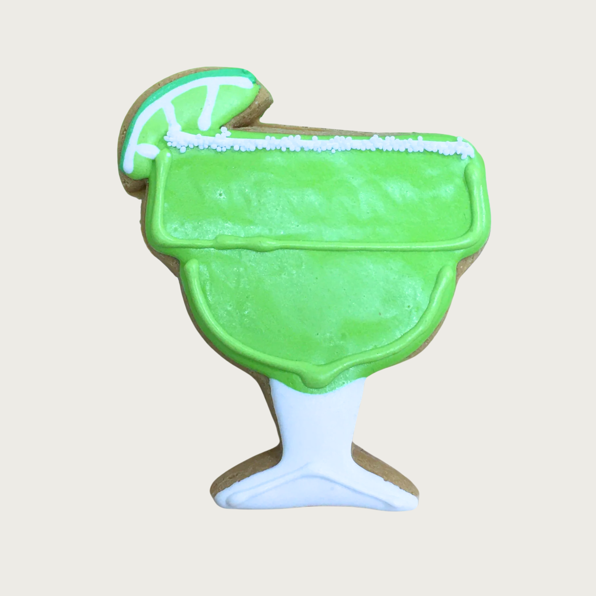 Dog cookie shaped like a margarita glass with lime "drink" and sliced lime garnish.