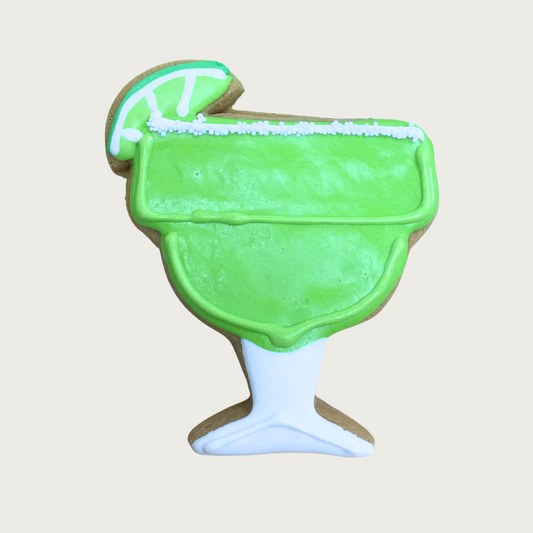 Dog cookie shaped like a margarita glass with lime "drink" and sliced lime garnish.