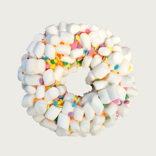 Thick, donut-shaped dog cookie covered with mini marshmallows and decorated with multicolored sprinkles.