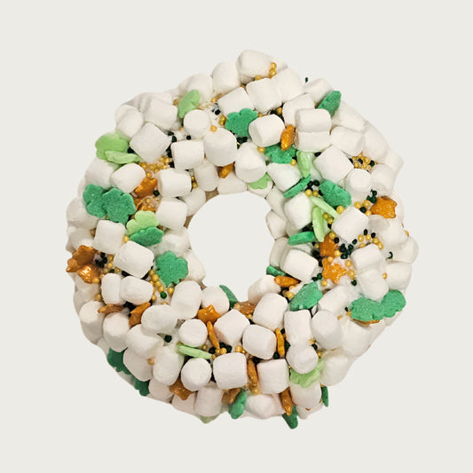 St. Patrick's Day themed, donut shaped dog cookie dipped in vanilla coating, and covered with tiny marshmallows, and accented with clover shaped decorettes, gold stars, and black & gold non-pareils.