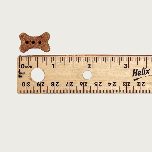 One mini bone treat next to a ruler to show size. It is just under 1" long.