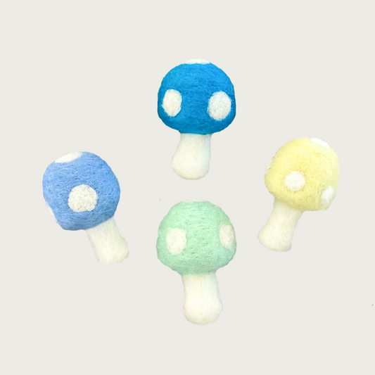 Four small felt mushroom shaped cat toys. All have white stems and blue, yellow, or green caps with white dots.