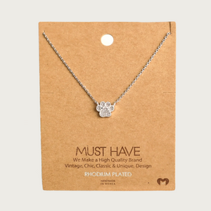 Delicate silver-toned, fine-linked chain necklace featuring a silver-toned dog paw print charm filled with cubic zirconia stones. Charm is connected to the necklace on two sides-it does not dangle.