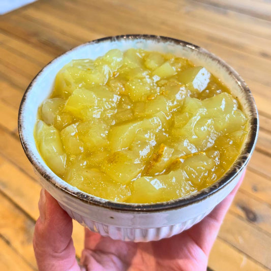 A bowl of homemade pork bone broth for pets made with turmeric (gives it a deep golden color). It has a gelatinous texture.
