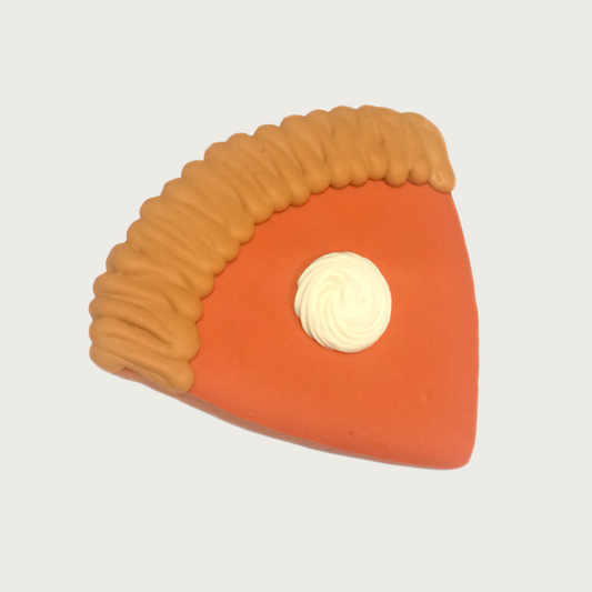 Decorated dog cookie in the shape of a slice of pumpkin pie. Tan crust with orange "filling" and dollop of "whipped cream".
