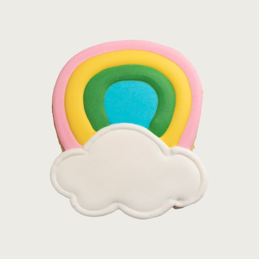 Rainbow shaped dog cookie. It has an inverted U-shape, with both ends meeting in a white cloud.