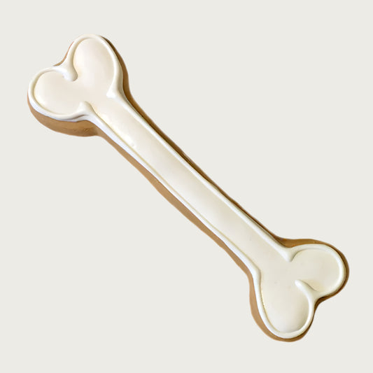 Long, white, bone-shaped dog cookie.