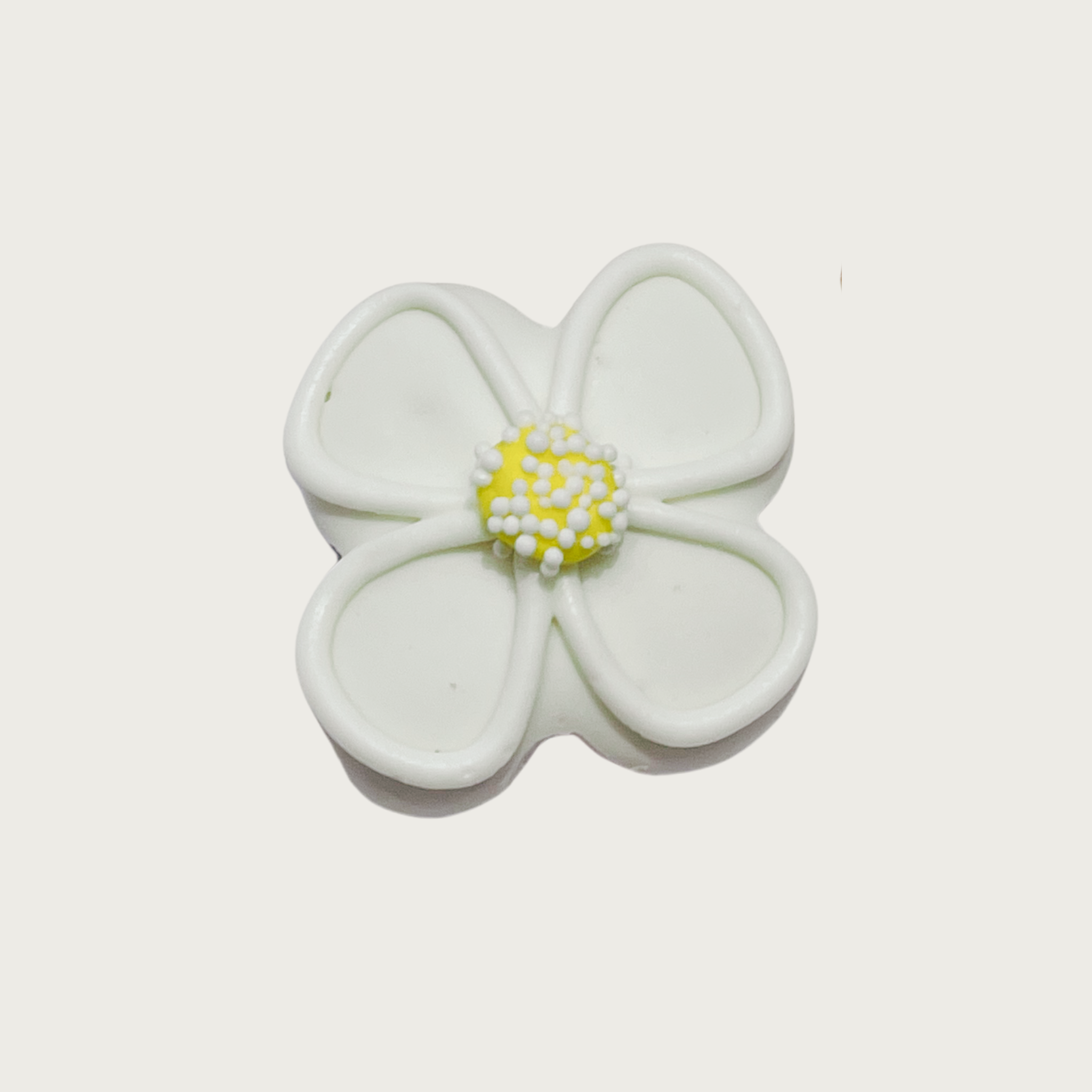 Decorated mini dog cookie shaped like a white daisy flower with yellow center, with white nonpareil sprinkles on top of the yellow center.