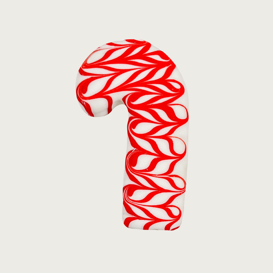 Dog cookie shaped like a candy cane. It is covered in a white coating with red swirls.