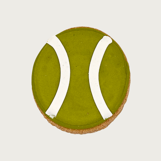 Tennis ball shaped decorated dog cookie. It is olive green with two white stripes.