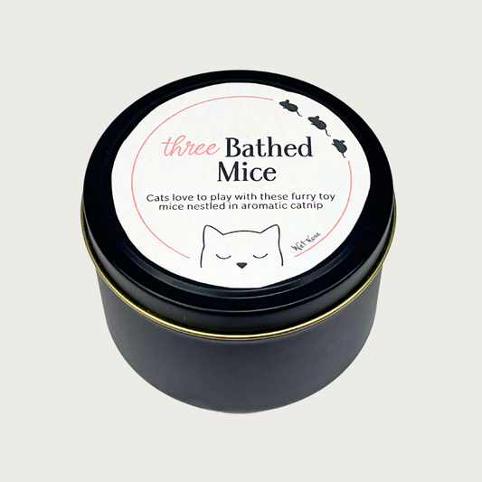 Matte black metal tin with a label for 'Three Bathed Mice' cat toys. Text reads "Cats love to play with these furry toy mice nestled in aromatic catnip" by Wet Nose.