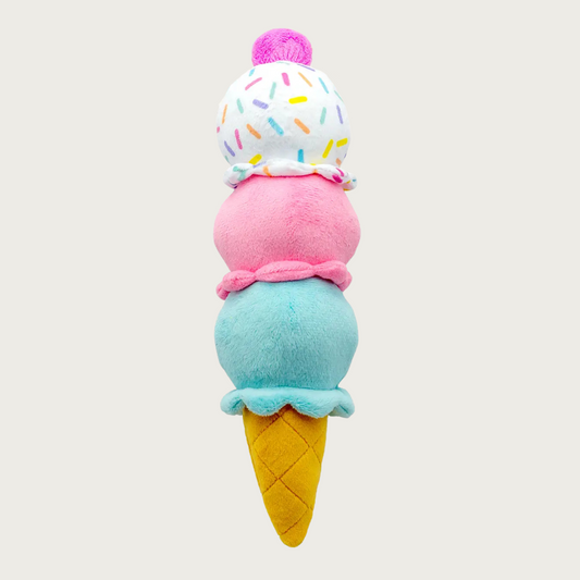 Plush dog toy in the shape of a triple-scoop ice cream cone. Cone part is tan, bottom scoop is pale blue, middle scoop is pink, top scoop is white with pastel sprinkle pattern, and hot pink "cherry" on top.