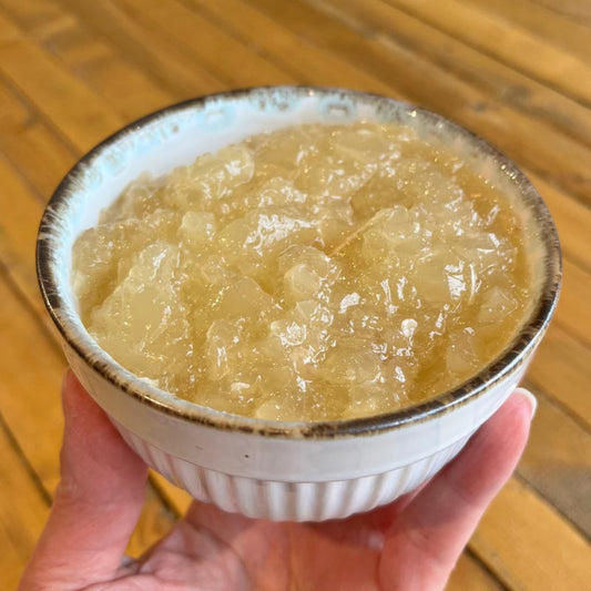 A bowl of homemade Turkey Bone Broth for pets, that's light golden yellow in color and gelatinous in texture.