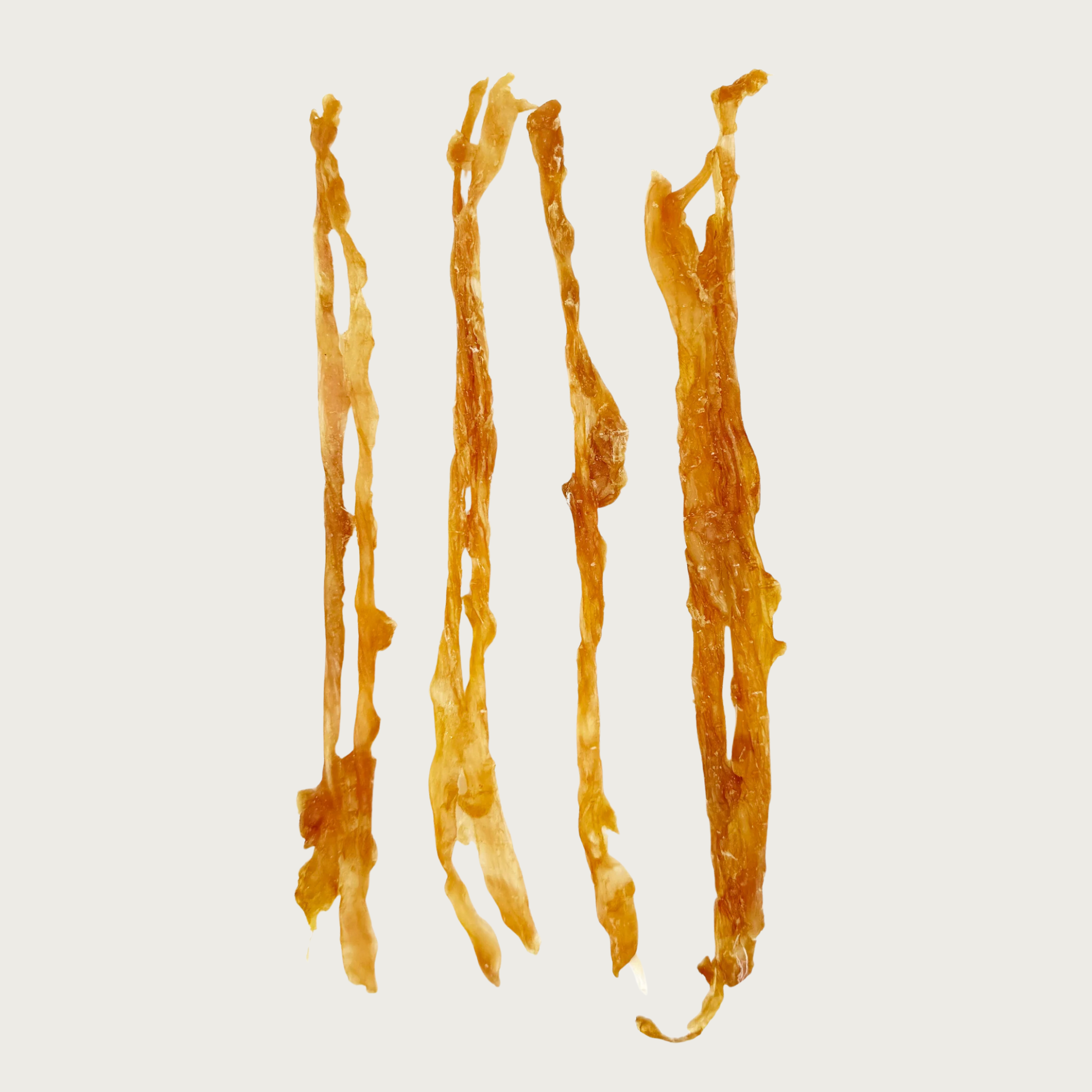 Four individual Turkey Twist dog treats side by side to show size & shape variation. They are thin and dark tan in color.