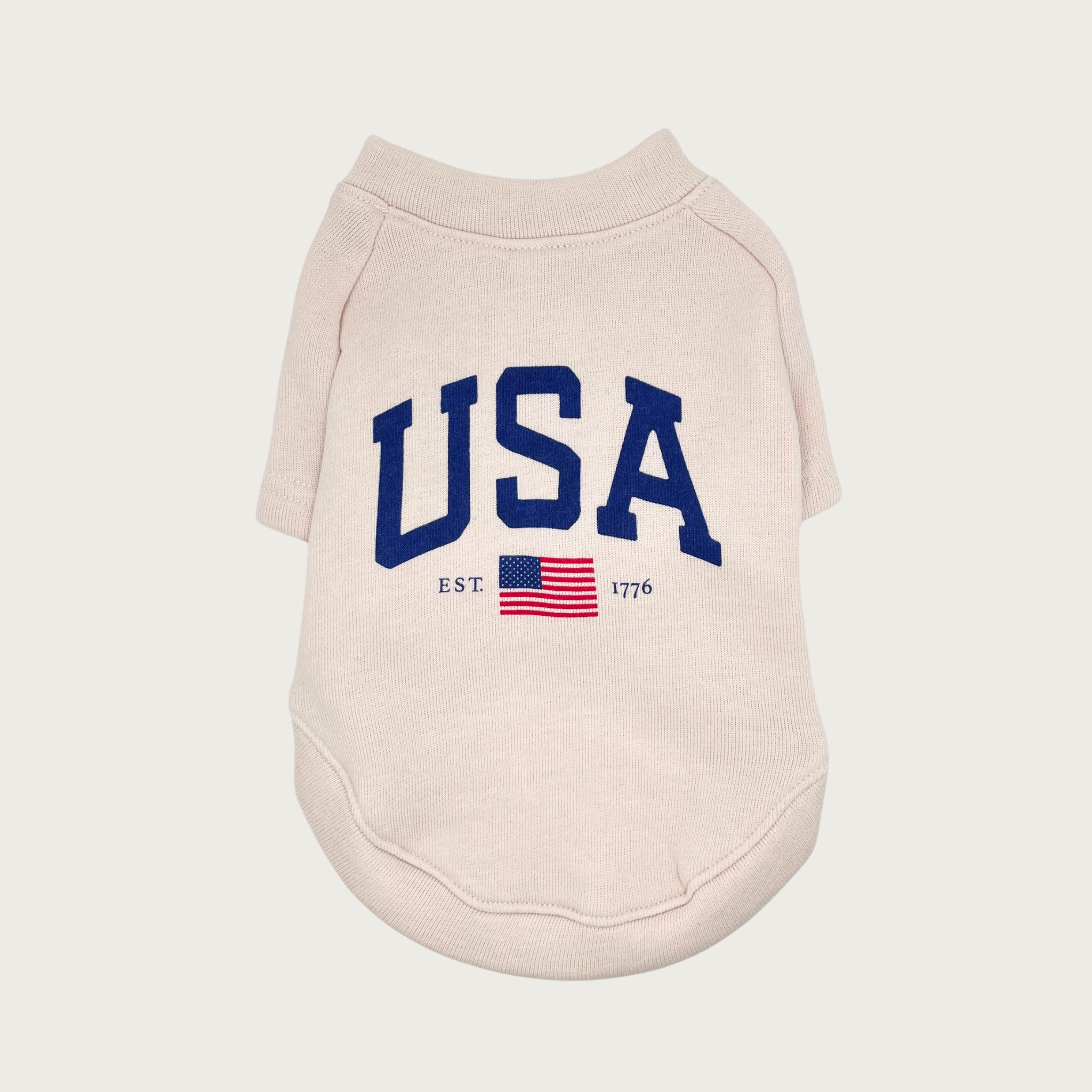 Cream colored pet sweatshirt with large "USA" navy blue text in center, with a smaller USA flag underneath with "EST." text on left side and "1776" on the right side.