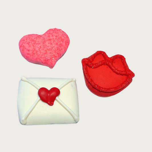 Valentine's themed mini dog cookies,  including a pink heart with sparkly pink sugar, white envelope sealed with a red heart, and red lips (kiss).