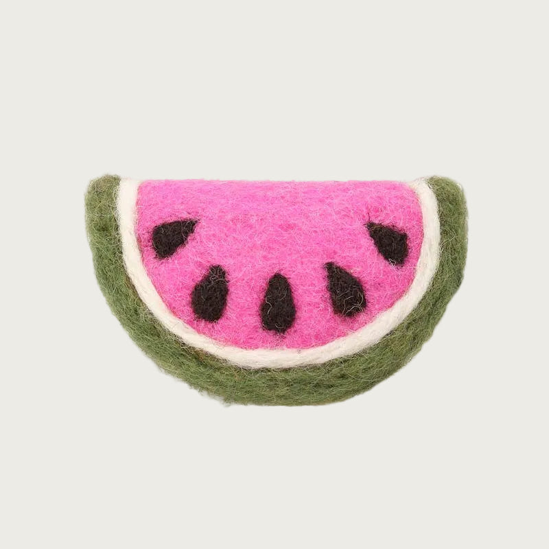 A felted wool cat toy shaped like a wide slice of watermelon, with a pink inner section with black seeds, a white inner rind, and a green outer rind.