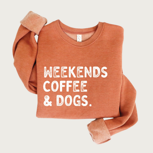 Heathered orange crewneck sweatshirt, with "Weekends, Coffee & Dogs" on chest in large, all caps, distressed white text.