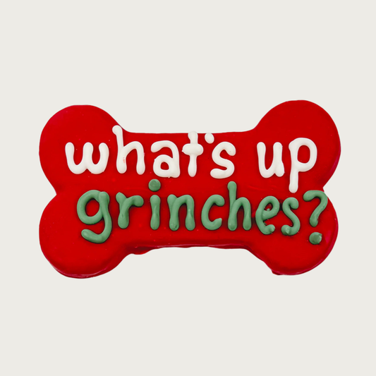 Red bone-shaped dog cookie with white & green text that reads "what's up grinches?"