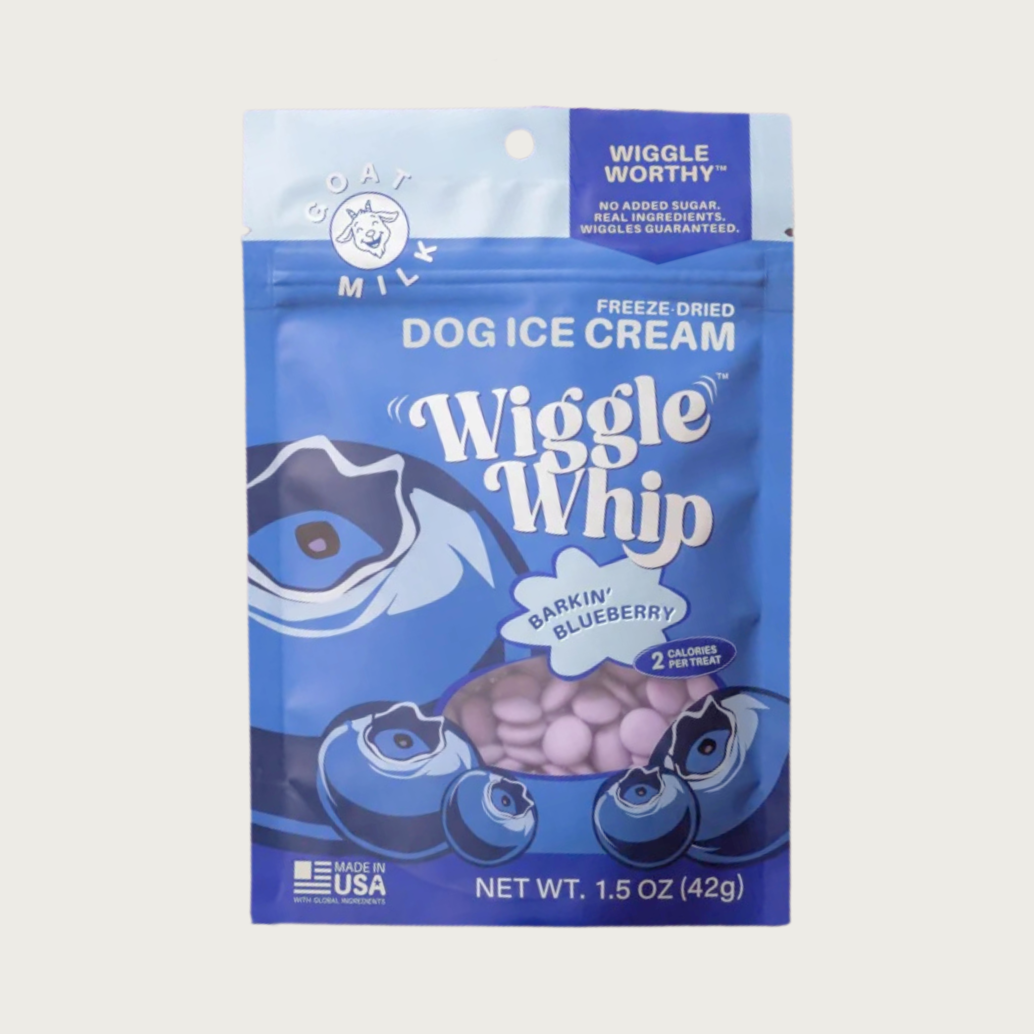 A pouch of Wiggle Whip Freeze Dried Dog Ice Cream in Barkin' Blueberry flavor. The packaging is bright blue with illustrations of whole blueberries, with a small transparent window showing the small, light purple, disc shaped treats.
