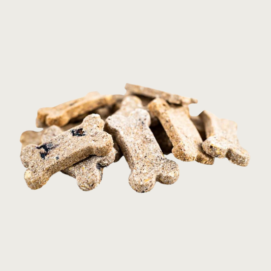 Closeup of a small pile of Berry Boost Bones dog treats. They are dog bone shaped, beige in color with visible berry pieces inside, with a grainy texture.