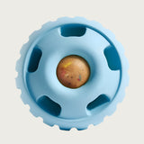 Light blue, round Pupsicle toy. Center has a small, depressed, round open area for dog to access a treat. Around this opening, are 5 smaller slot-type openings (called "drool slots"), to provide additional access and collect excessive drool. Bottom half of toy is solid rubber with an indentation to twist toy apart.