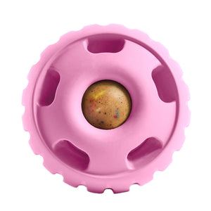 Medium shade of pink, round Pupsicle toy. Center has a small, depressed, round open area for dog to access a treat. Around this opening, are 5 smaller slot-type openings (called "drool slots"), to provide additional access and collect excessive drool. Bottom half of toy is solid rubber with an indentation to twist toy apart.