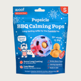 Load image into Gallery viewer, 10 ct bag of small Woof BBQ Calming Pops, long-lasting refill treats for the Pupsicle toy to promote calm. Extra long lasting, less mess. Image of red, white & blue tie-dyed Pupsicle toy is in center, with refill pop inside, with sample pops clustered to the right. They are round, tan colored balls, coated with bacon powder.
