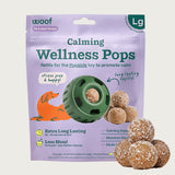 7 ct bag of large Woof Calming Wellness Pops, long-lasting refill treats for the Pupsicle toy to promote calm. Extra long lasting, less mess. Image of green Pupsicle toy is in center, with refill pop inside, with sample pops clustered to the right. They are round, peanut butter colored, smooth balls, coated with coconut flakes.