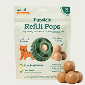 10 ct bag of small Woof Pupsicle Refill Pops, long-lasting refill treats for the Pupsicle toy. Extra long lasting, less mess. Image of green Pupsicle toy is in center, with refill pop inside, with sample pops clustered to the right. They are round, peanut butter colored, smooth balls.