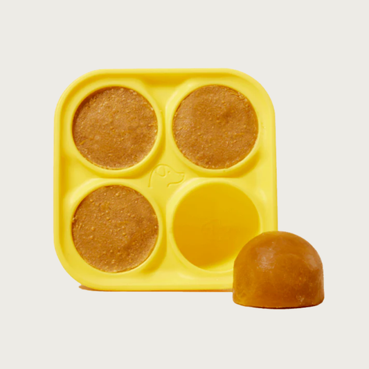 Yellow silicone dog treat mold with four circular, deep cavities.