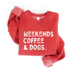 Heathered cranberry red crewneck sweatshirt, with "Weekends, Coffee & Dogs" on chest in large, all caps, distressed white text.