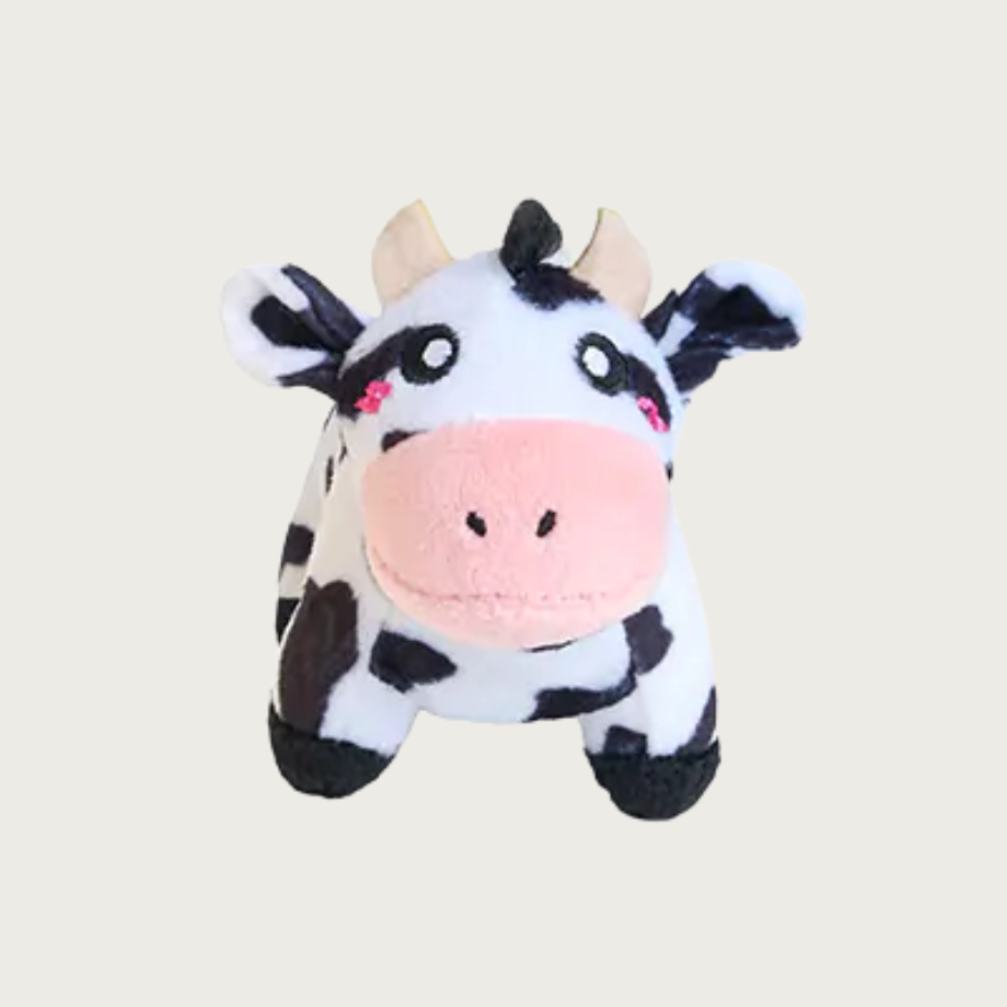 A cute plush dog toy cow with black and white spots, a pink snout, and small horns.