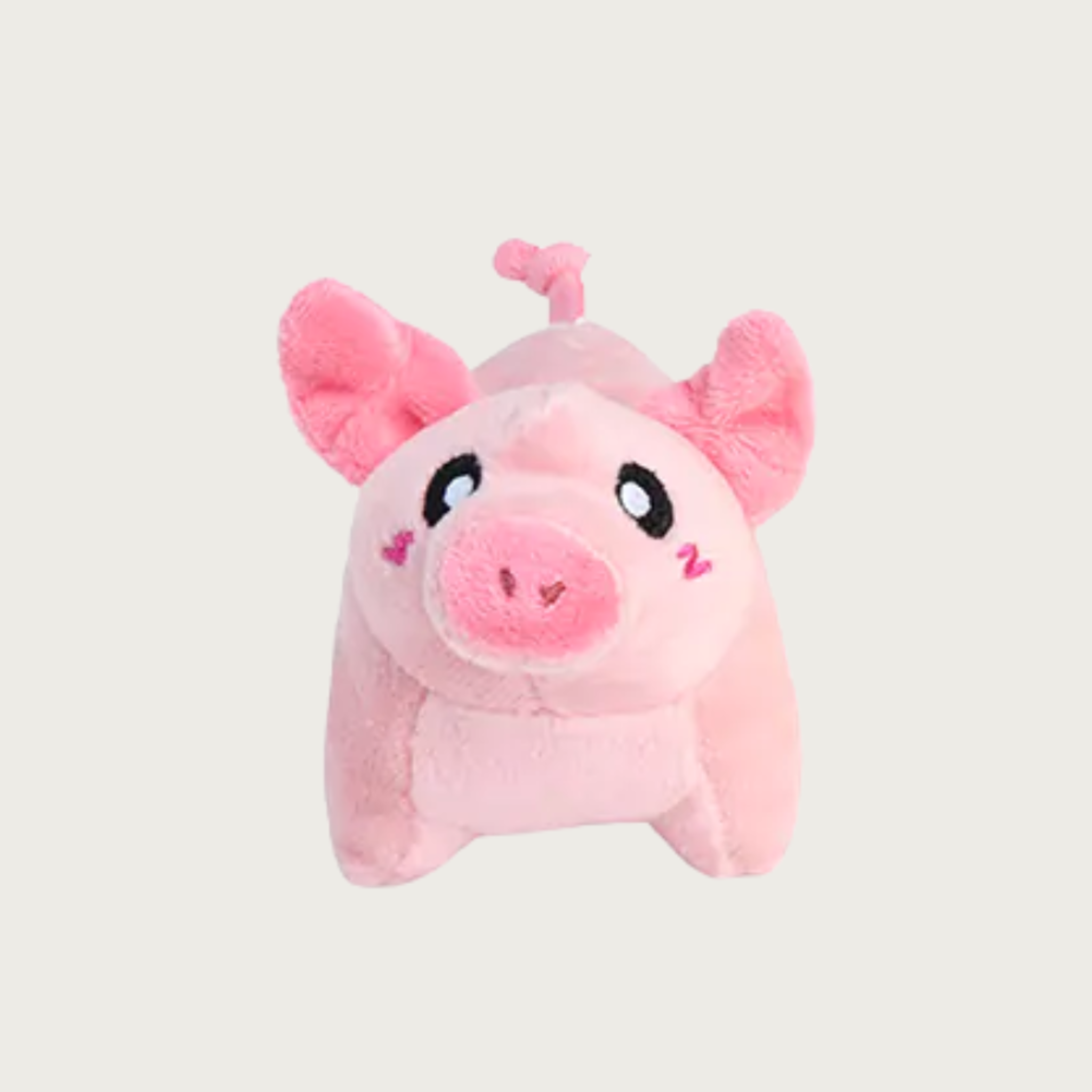 A pink plush pig dog toy with floppy ears, black and white eyes, and embroidered pink cheeks.