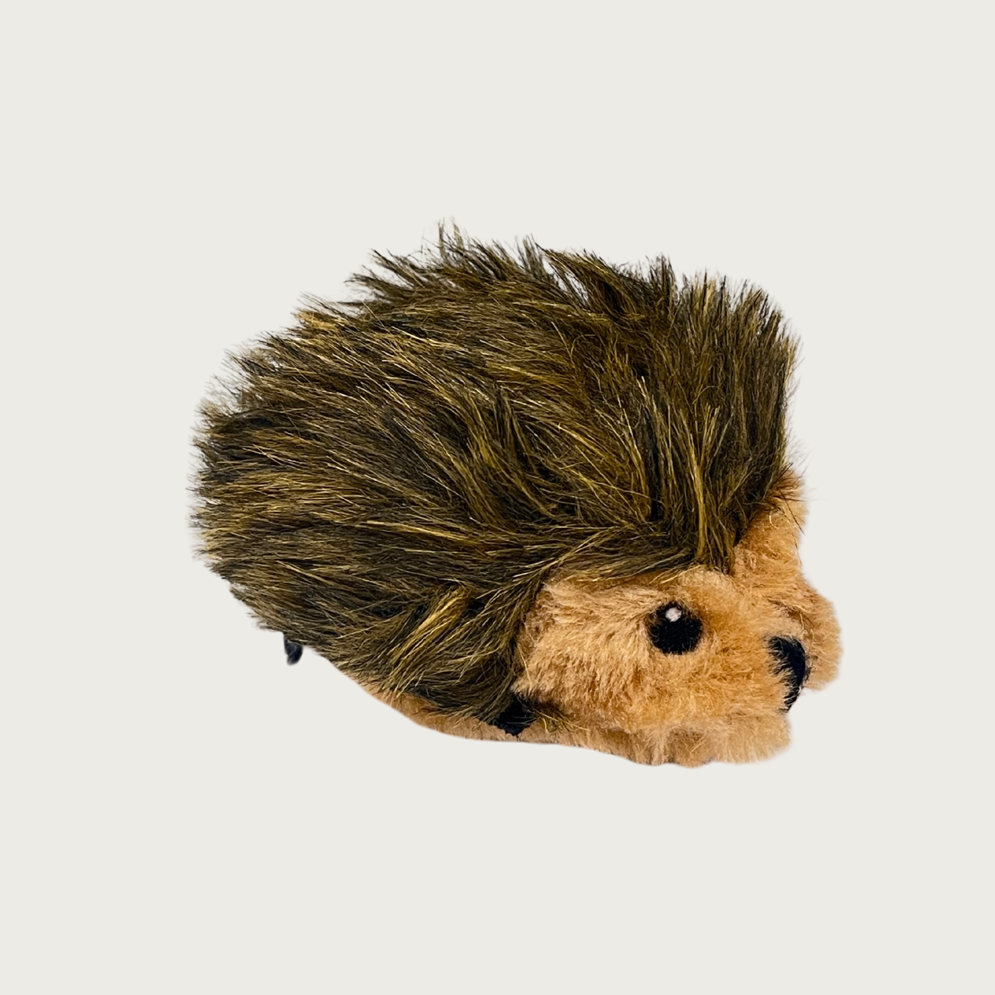 A small plush hedgehog dog toy with dark brown and black spiky fur and a tan face, with embroidered eyes & nose.