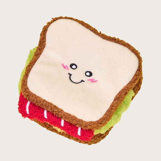 Plush dog toy shaped like a bacon, lettuce & tomato sandwich with a cute smiling face.