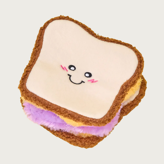 Plush dog toy shaped like a peanut butter & grape jelly sandwich with a cute smiling face.