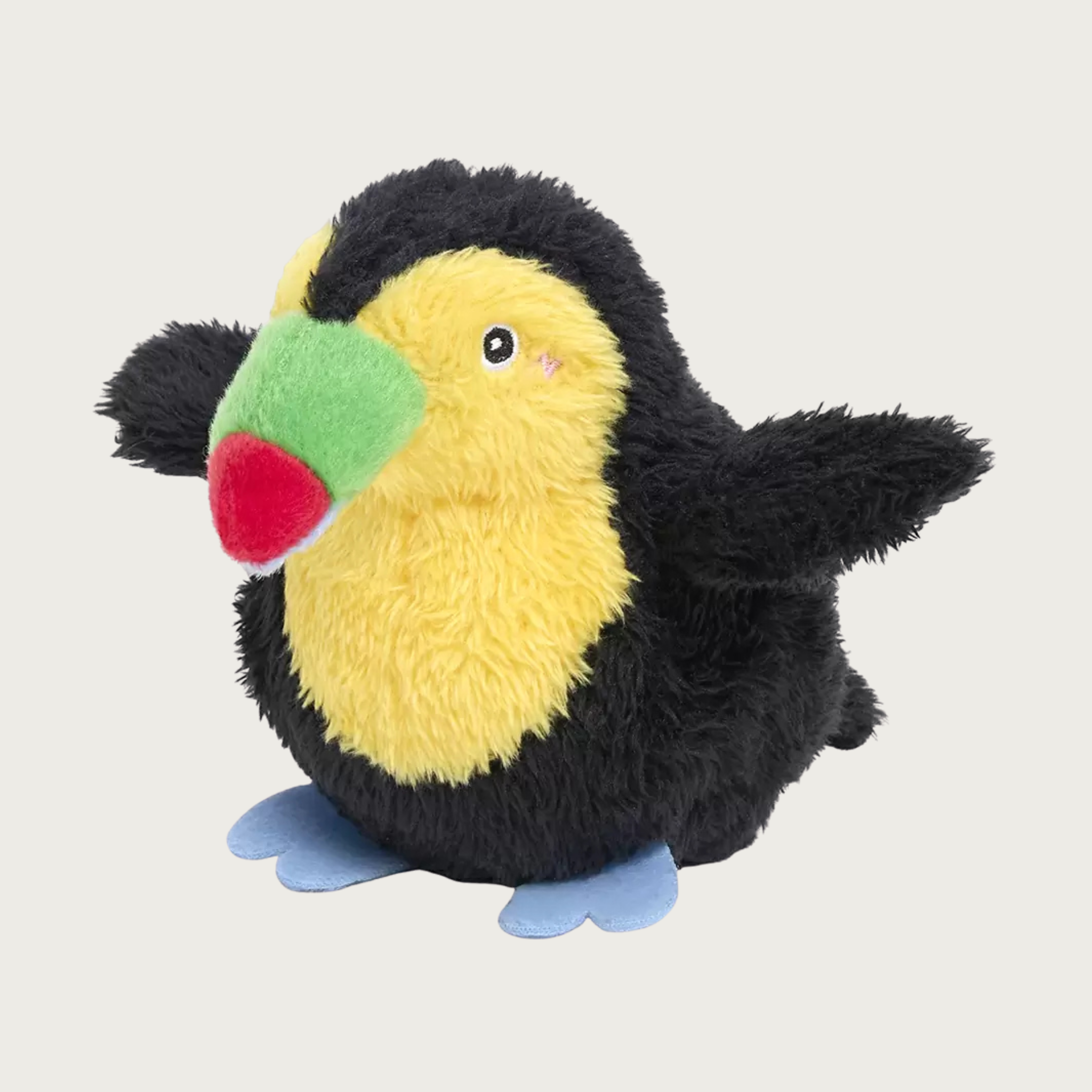 A plush toucan dog toy sitting up, with a black body, yellow face and chest, a green & red beak, and blue feet. Embroidered facial details.