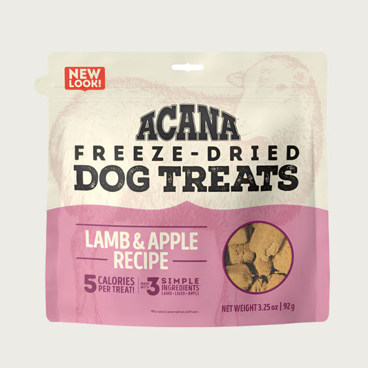 3.25 oz beige & pink bag of Acana Freeze-Dried Dog Treats, Lamb & Apple Recipe. 5 calories per treat, made with 3 simple ingredients. Small transparent window show product inside; small tan-colored, cube shaped treats.