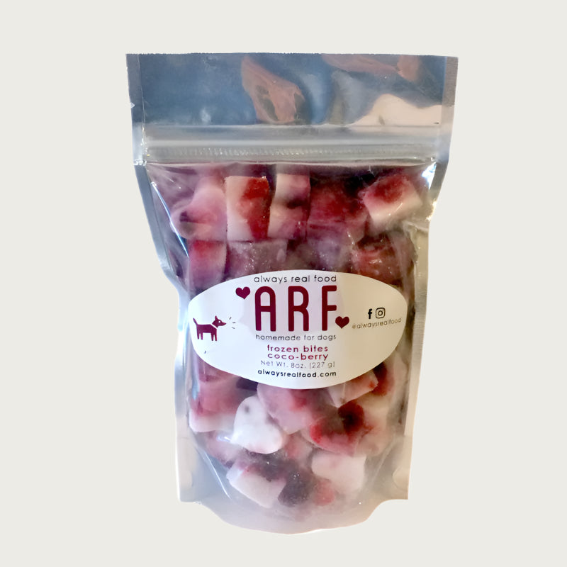 8 oz clear bag of frozen Always Real Food (ARF) Coco-Berry Bites. Can see product inside-they are layered white & red, heart-shaped cubes.