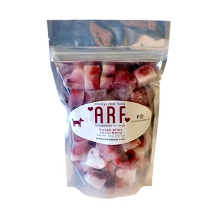 8 oz clear bag of frozen Always Real Food (ARF) Coco-Berry Bites. Can see product inside-they are layered white & red, heart-shaped cubes.