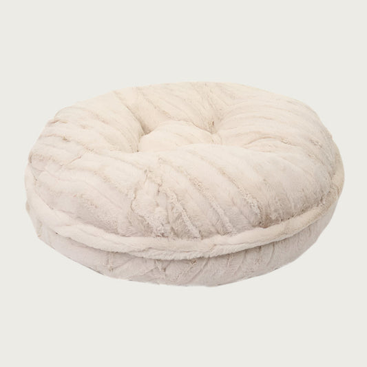 Side view of the Bagel Bed in Cream Mink. A ring of fabric goes along the center edge of the bed, hiding the zipper.